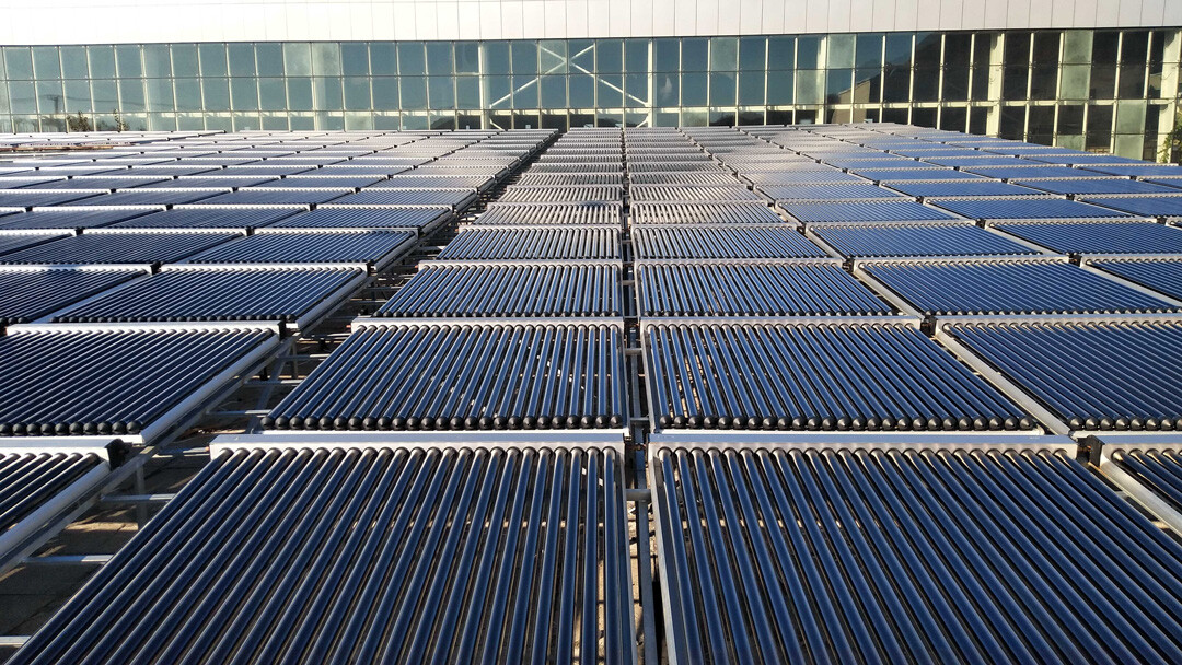 Rows of raised evacuated-tube solar collectors arranged across a building roof